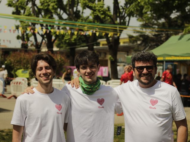 Tre volontari di Project Nicky sorridenti durante un evento sportivo